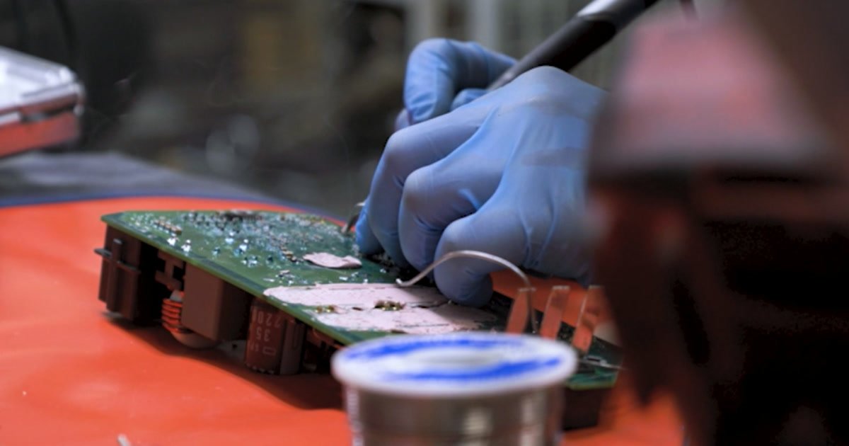 A FACAR technician repairing a steering control unit circuit board
